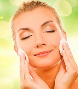 Woman rubs her face with cotton pads