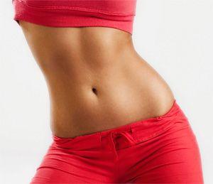 Flat stomach of a girl in red shorts