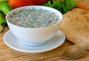 Summer okroshka in a white deep plate on the table