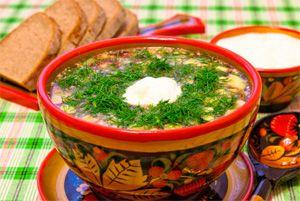 Okroshka in a wooden deep plate with Russian painting