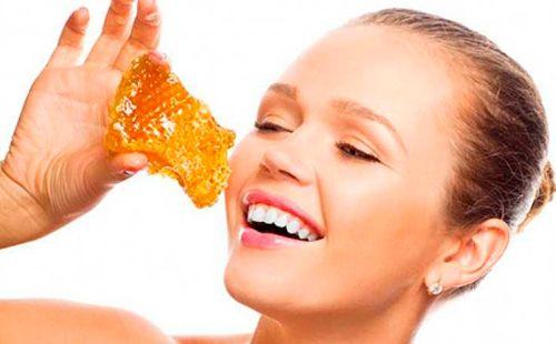 Girl holds honeycombs in her hands.