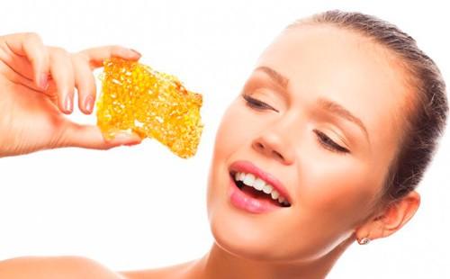 Girl holds honeycombs in her hands.
