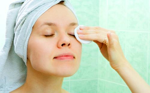 Girl removes makeup with a cotton pad