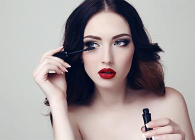 The girl paints eyelashes