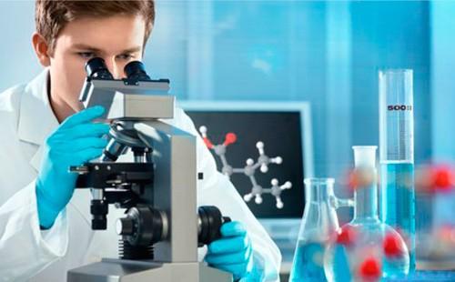 A man conducts a DNA test under a microscope.