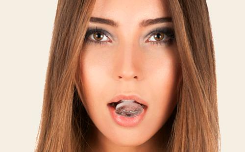 Girl holds ice cube in her mouth