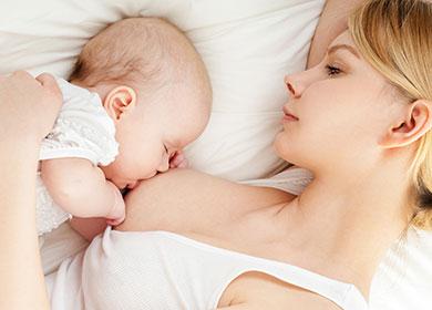 Young mother breastfeeds her baby