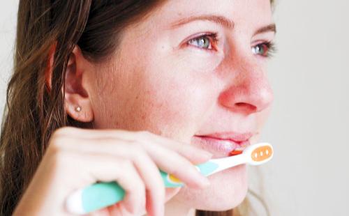Girl massages her lips with a brush