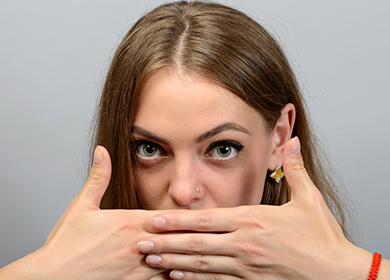 The girl covered her palms with her mouth