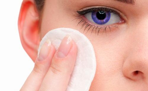 Blue-eyed girl with a cotton pad