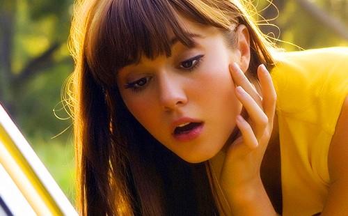 Girl peers in a car mirror