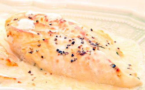 Chicken in a creamy sauce with pink pepper on a plate