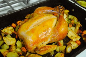 Baked chicken with apples on a baking sheet
