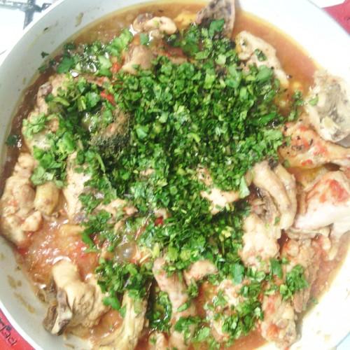 Chicken sprinkled with green onions in a pan