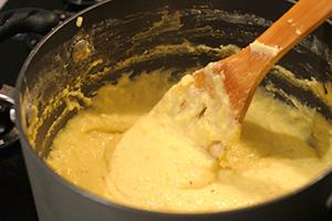 We interfere with the future polenta with a wooden spatula