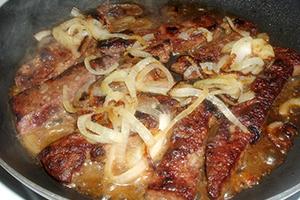 Beef liver fried in a pan with onion
