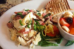 Egg white omelet with chicken and green pepper, served with fruit and toasted bread