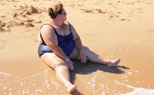 Bbw sitting on the sand at the beach