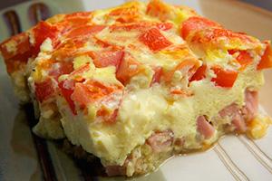 Portion baked omelet with ham and tomatoes