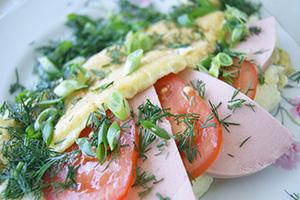 Omelet with boiled sausage, tomatoes and herbs
