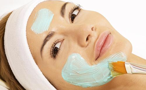 A brown-eyed woman is smeared with a blue substance on her face