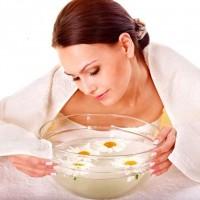 Woman steaming face with chamomile broth