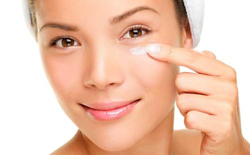 Brown-eyed girl puts moisturizer on her finger