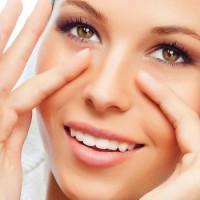 Girl with a smile performs a simple massage for the eyes