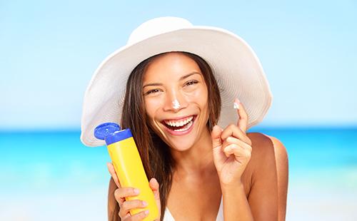 The girl in the hat smeared cream on her nose and laughs