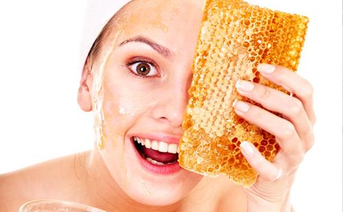 The brown-eyed woman is delighted with a piece of honeycombs