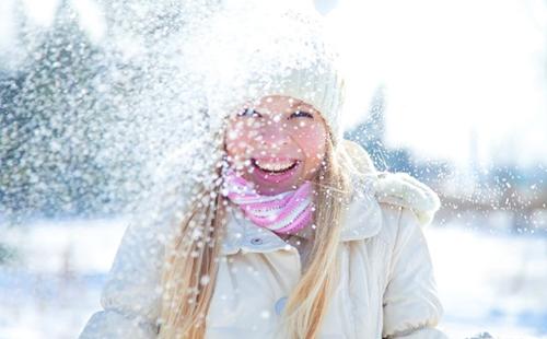 The girl in a white cap enjoys the snow