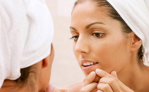 Girl squeezes black dots on her face