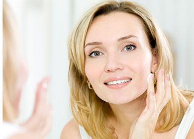 Girl puts cream on her face