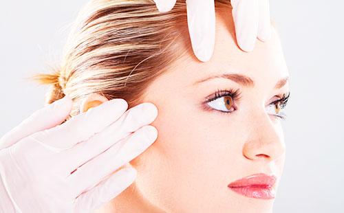 Gloved hands on forehead