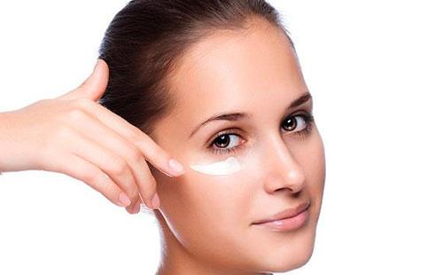 Girl smears cream under the eyes