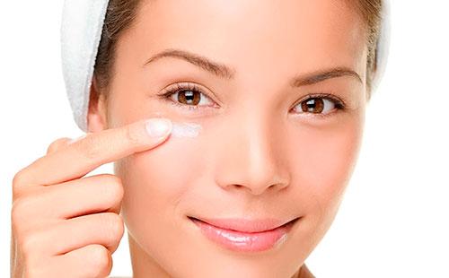 Girl puts cream under the eyes