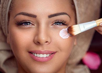 Girl puts a brush on her face with a brush