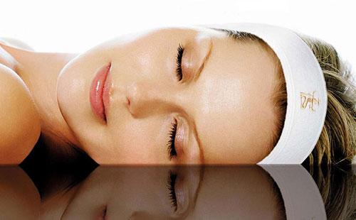 Girl lies with her eyes closed.