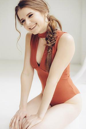 Laughing Ksenia in a red bodysuit
