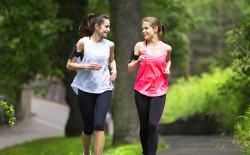 Two girls laughing and chatting while running