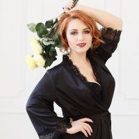 Lisa in black silk and with a bouquet of yellow roses