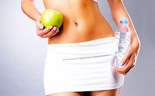 Apple and water bottle in hands