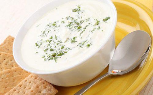 A cup of milk soup with herbs and crackers