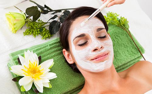 The girl is applied a white mask to her face