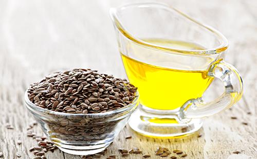 Dark seeds and a cup of yellow oil