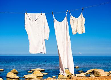 White shirts hang on the seashore.