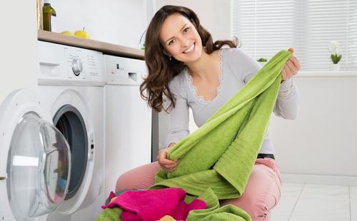 Girl pulls out the laundry from the washing machine
