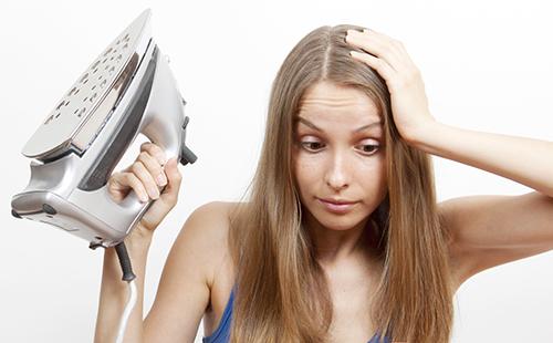 Woman with an iron holding her head