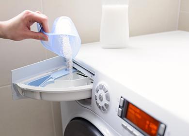 Woman pours powder into the compartment of the machine