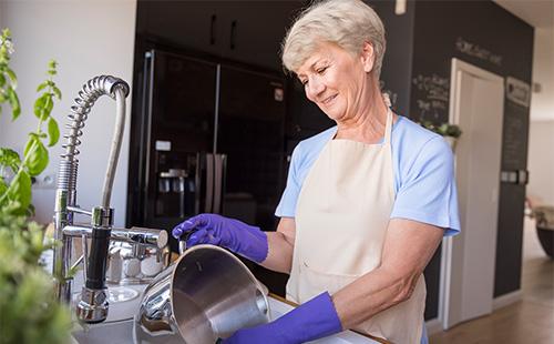 Woman washes a pan